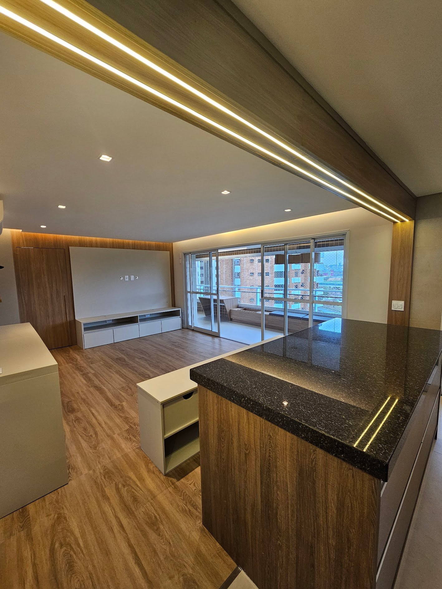 Apartamento reformado com cozinha integrada e acabamento em madeira
